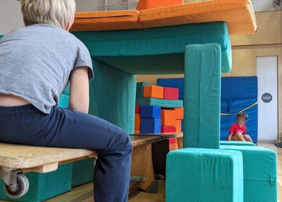 Kinder bauen ein Haus aus Sportmatten