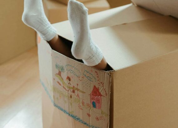 Kind spielt Verstecken im Karton